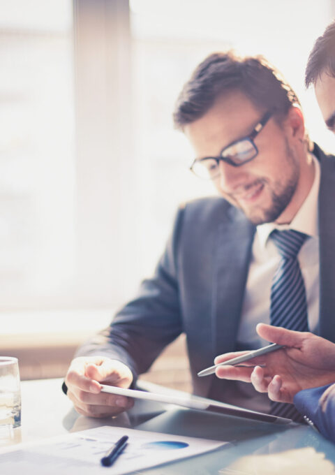 Image,Of,Two,Young,Businessmen,Using,Touchpad,At,Meeting