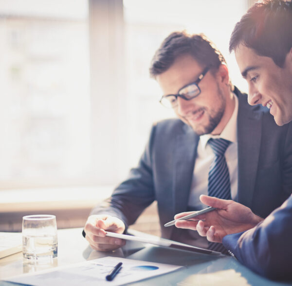Image,Of,Two,Young,Businessmen,Using,Touchpad,At,Meeting